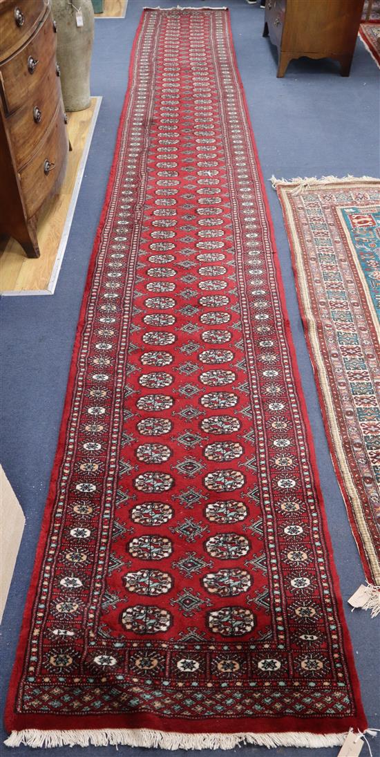 A Bokhara burgundy ground runner 590 x 78cm